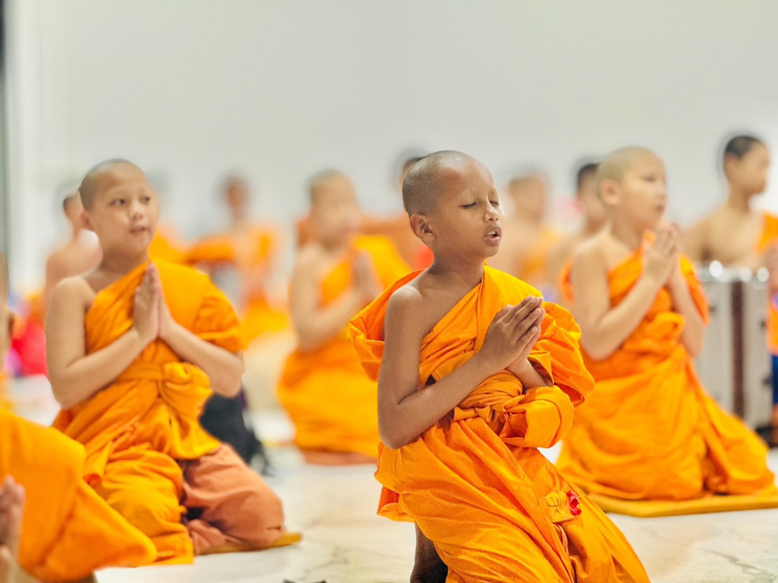 Young novices in orange robes walking in a line